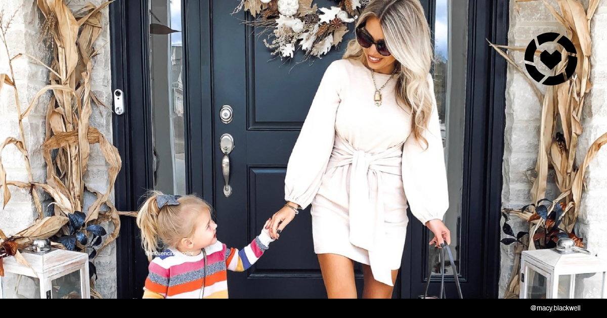 Woman holding hands with daughter on front porch