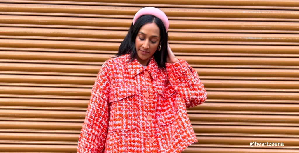A content Creator posing for a picture wearing a pink and red wool button-up with a pink headband