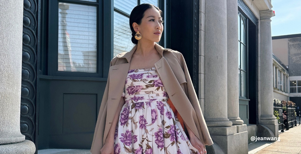 Creator @jeanwang wearing a flowy off-white dress with a pattern of purple flowers. 