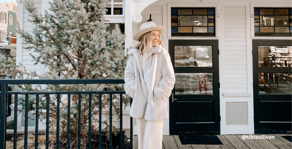 Content creator @tibisullivan wearing a jacket on her porch enjoying the winter weather. 